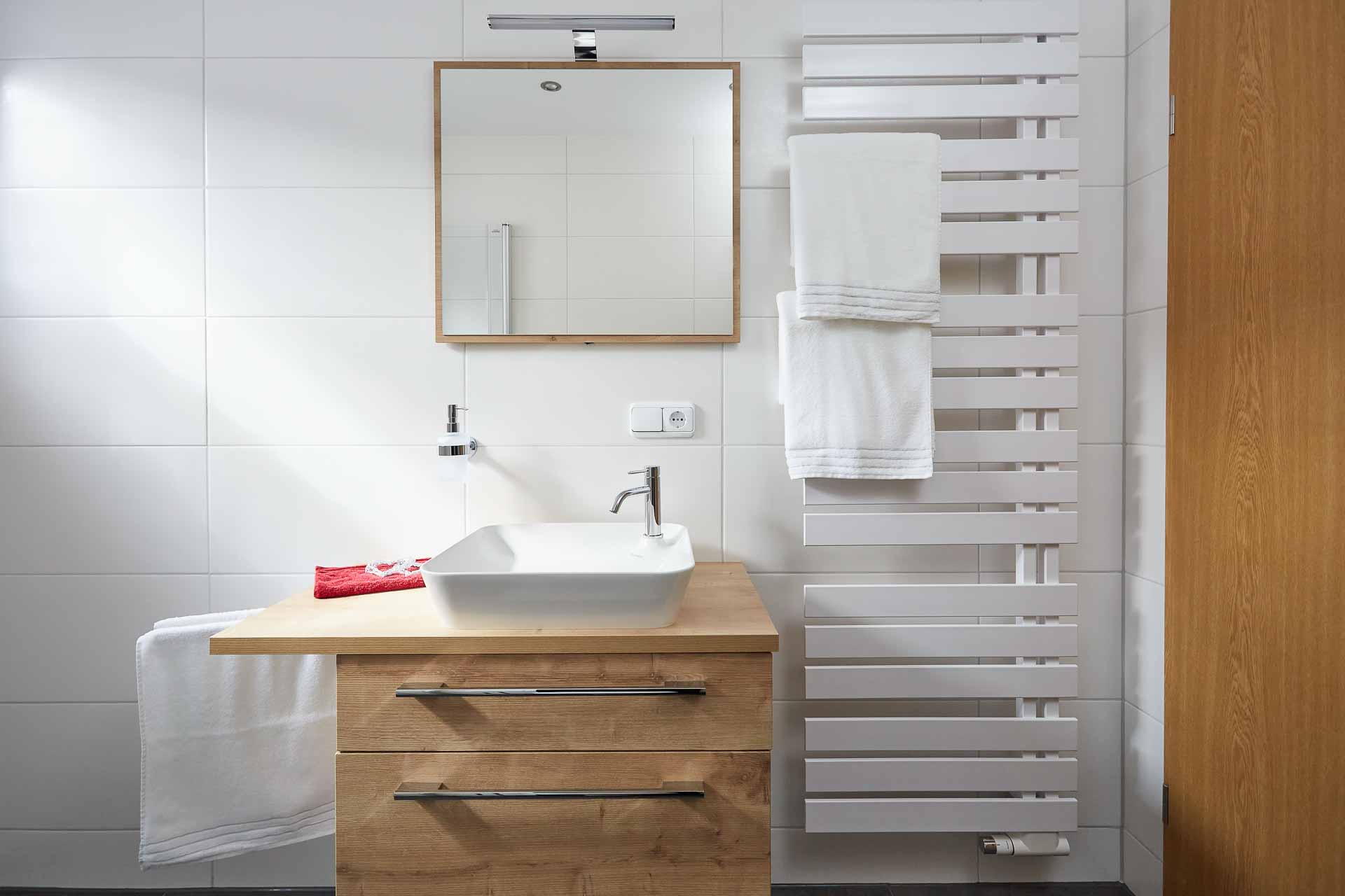 Waschbecken mit Unterschrank, Spiegel und Handtuchhalten im Badezimmer