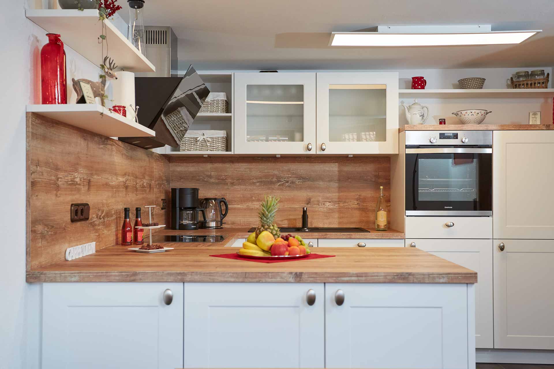 Gut ausgestattete Küche mit Ofen, Kaffeemaschine, Dunstabzug