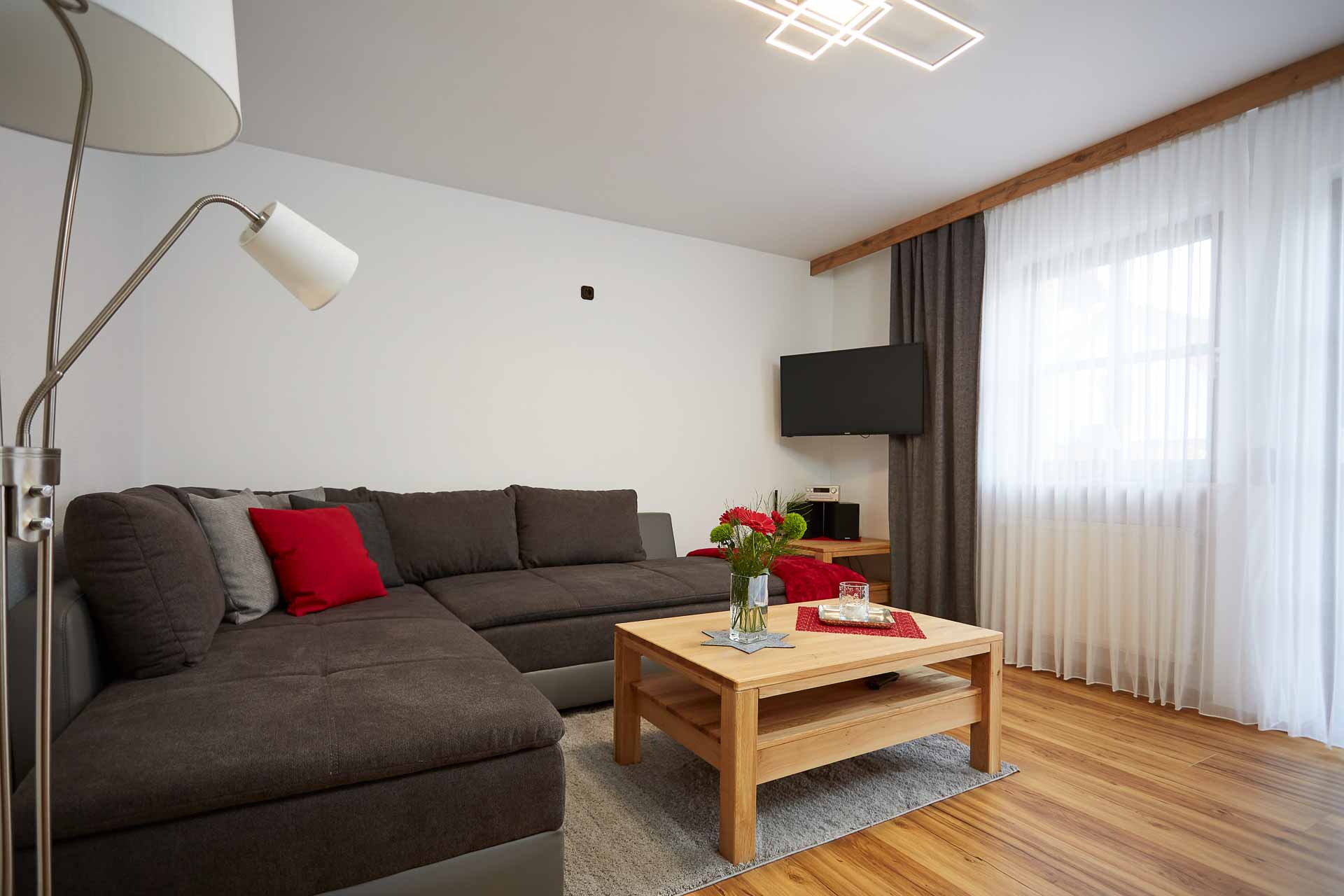 Wohnzimmer mit Ecksofa, Couchtisch und Fernseh